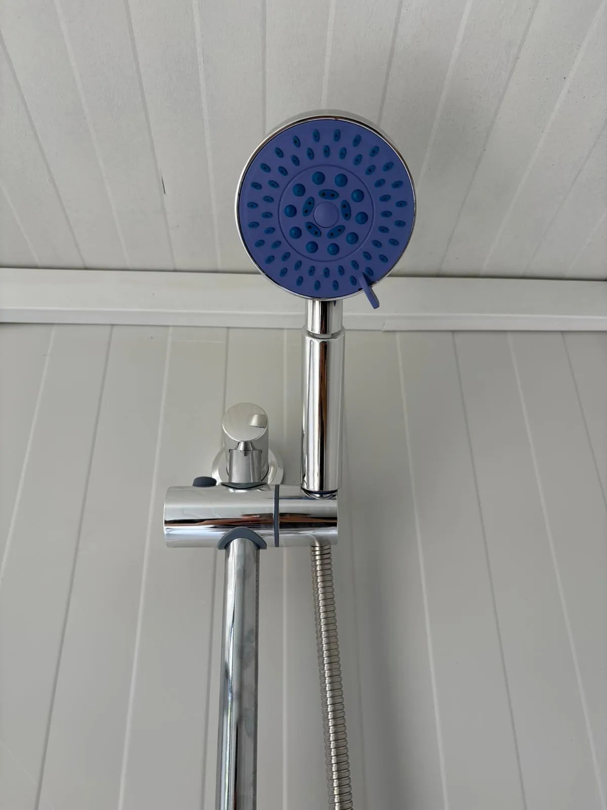 Shower head inside a portable bathroom unit.