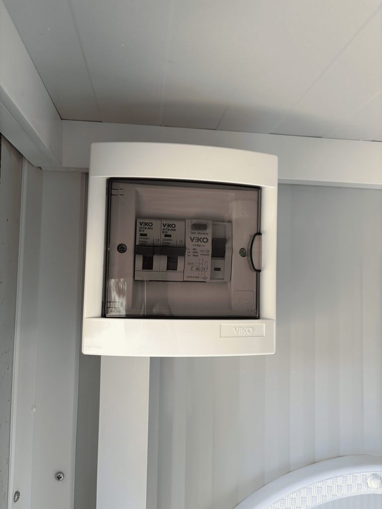 Fuse box inside a portable shower unit for camping.