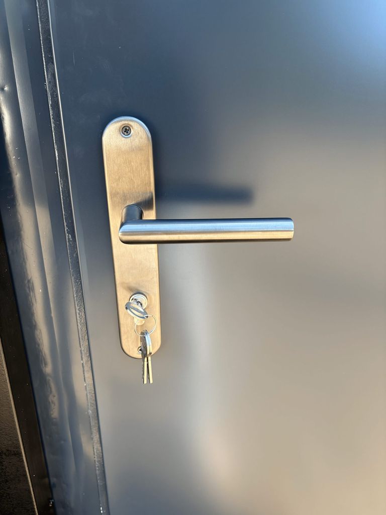 Fuse box and door handle inside a portable shower unit for camping.