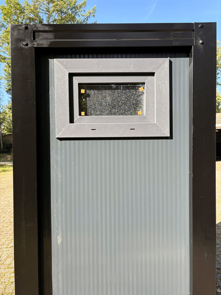 Exterior view of a portable shower unit for camping with the window closed.